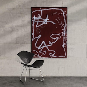 May include: A rectangular wall art piece featuring a deep maroon background with white, hand-drawn, scribbled line art, including star shapes and abstract loops. Below the art, a black wire-frame chair with a black leather seat is positioned.