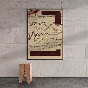 May include: A framed rectangular wall art piece featuring a beige background with dark maroon horizontal bars at the top and bottom, thin dark brown wavy lines, and the handwritten text "Music Honey Maxwell" in the center of the composition.