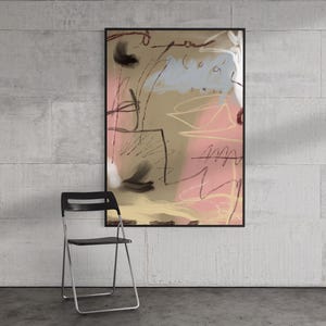 May include: A rectangular wall art print in a black frame featuring an abstract composition with beige, soft pink, and light blue color blocks, accented by thin black scribbled lines and dark brushstrokes, displayed above a black folding chair.