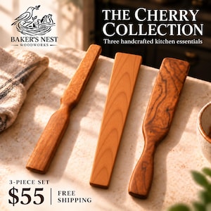 May include: A set of three wooden kitchen utensils from The Cherry Collection by Baker's Nest Woodworks. The set includes two spatulas with contoured handles and one flat, rectangular wooden paddle, all featuring natural wood grain patterns.