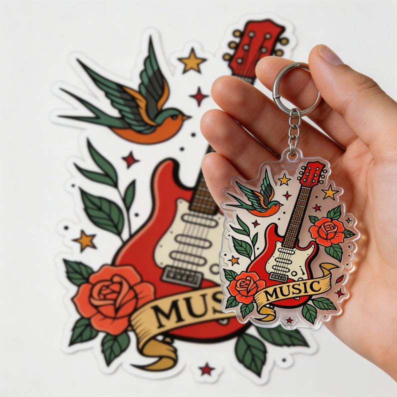 May include: A clear acrylic keychain featuring a red guitar, roses, a swallow bird, and the word "MUSIC" on a banner. The keychain is held in a hand, with a matching sticker in the background.