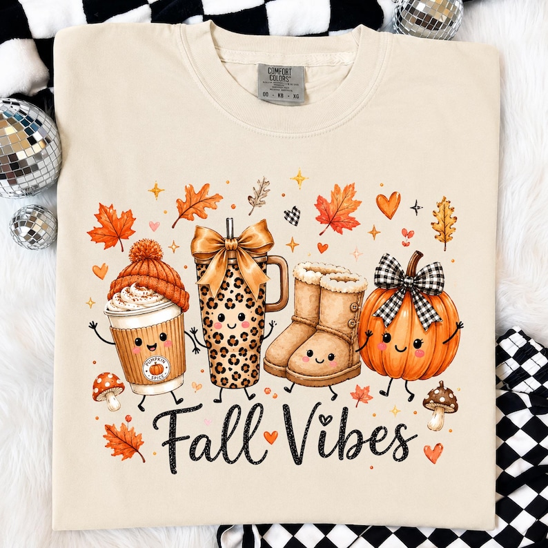 May include: A beige t-shirt featuring a graphic print of a coffee cup with a beanie, a leopard print tumbler with a bow, tan boots, and a pumpkin with a plaid bow. The text "Fall Vibes" is printed below, surrounded by autumn leaves and hearts.