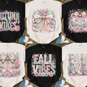 May include: A collection of six t-shirts in black and cream, featuring graphic prints of pumpkins, bows, flowers, and cowboy boots. The designs include text reading AUTUMN VIBES and FALL VIBES, rendered in pastel colors with floral and checkered patterns.