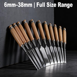 May include: A set of wood chisels with wooden handles and metal blades. The chisels are arranged in a row, with the text "6mm-38mm | Full Size Range" at the top. The chisels are designed for woodworking and are displayed against a dark background.