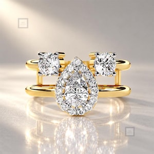 May include: A gold ring featuring a central pear-shaped diamond surrounded by a halo of smaller round diamonds. Two additional round diamonds are set on the upper band, creating a multi-layered design with a polished yellow gold finish.