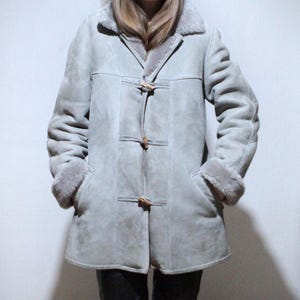 oversized sheepskin jacket with grey shearling interior and wooden buttons
