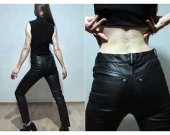 May include: Black leather pants with a slim fit and a high waist. The pants have a zipper fly and belt loops. The back pockets are visible.