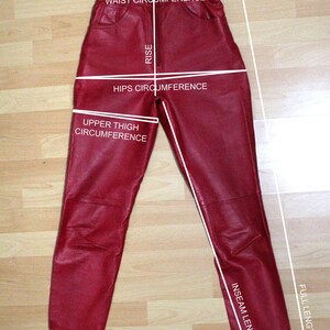 Puede incluir: Pantal&oacute;n de cuero rojo con medidas para la cintura, las caderas, la parte superior del muslo, la entrepierna y la longitud total.