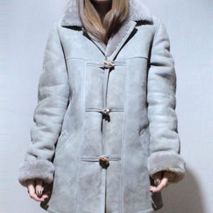 oversized sheepskin jacket with grey shearling interior and wooden buttons