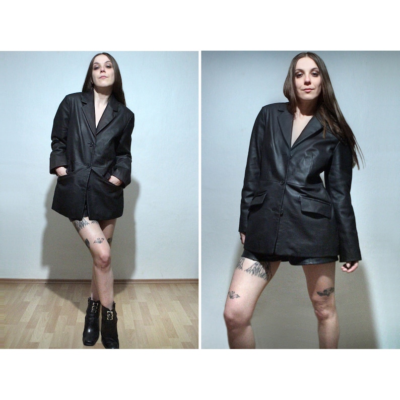 tattooed model wearing black leather blazer with high waisted leather shorts and ankle boots