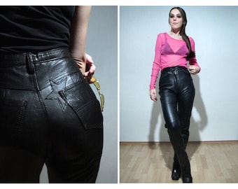 May include: A pair of black leather pants with a star detail on the back pocket. The pants are high-waisted and have a slim fit.