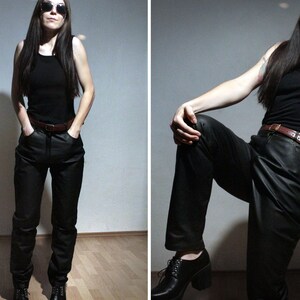 model wearing all black outfit with black leather pants and black cotton tee shirt