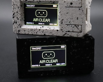 Puede incluir: Dos dispositivos digitales rectangulares apilados verticalmente. El dispositivo superior es blanco con motas negras, y el inferior es negro con motas grises. Cada pantalla muestra el texto TRACEPET, un icono de cara sonriente y AIR CLEAR.