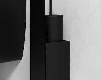 May include: A matte black wall-mounted toilet brush holder featuring a tall, vertical oval backplate and a square-shaped container. The cylindrical brush handle extends upward from the center of the circular lid, creating a sleek, uniform appearance.
