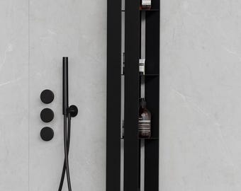 May include: A matte black vertical shower system featuring a tall, narrow integrated shelving unit with multiple compartments for toiletries, a handheld shower head with a flexible hose, and three circular control knobs mounted on the wall.