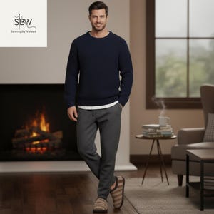 May include: A person wearing a navy blue sweater, gray sweatpants, a white undershirt, and striped slippers. The person is standing in front of a fireplace. The logo "Sewing By Waleed" is in the top left corner.