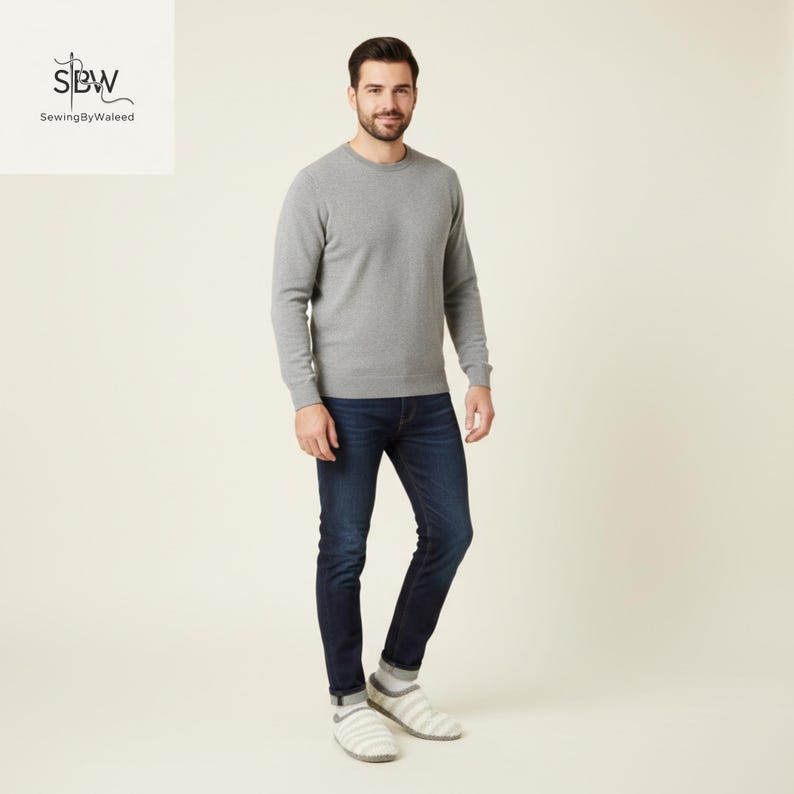 May include: A man wearing a gray crew neck sweater and dark blue jeans. The sweater has long sleeves and a ribbed hem. The jeans are a slim fit. The man is also wearing striped socks and slippers. The logo "SBW SewingByWaleed" is in the top left corner.