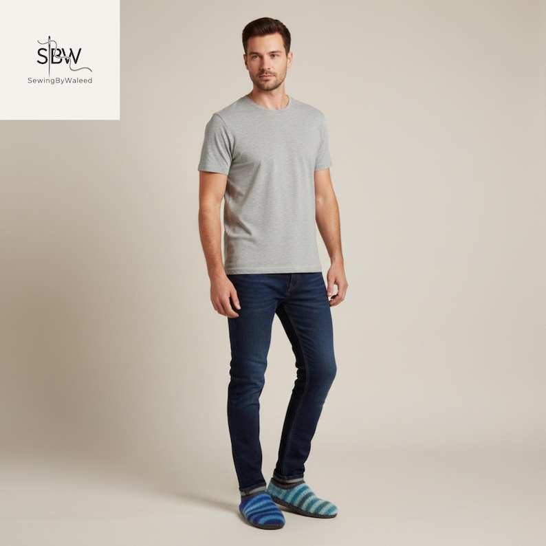 May include: A man wearing a gray crew neck t-shirt and dark blue jeans. He is also wearing blue and green striped socks. The image is set against a neutral background.