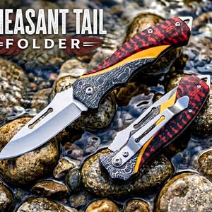 May include: Two folding knives labeled Pheasant Tail Folder. One knife is open with a silver blade, while the other is closed with a silver pocket clip. Both feature handles with red and black patterned scales, yellow accents, and dark textured bolsters.