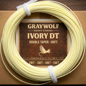 May include: A spool of ivory-colored fly fishing line, wrapped around a cardboard box. The box features a brown label with the text "GRAYWOLF HAPPY FISHING IVORY DT DOUBLE TAPER - 80FT". The line is secured with a white band.