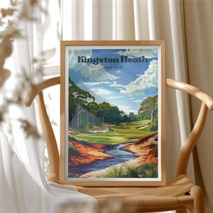 May include: A framed art print featuring a golf course landscape with the text "Kingston Heath Golf Club." The artwork depicts a sunny day with a blue sky, white clouds, and a winding river. The print is displayed on a wooden chair.