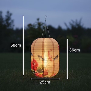 May include: A paper lantern with a floral design, measuring 23 inches tall, 14 inches wide, and 10 inches deep. The lantern is suspended by a wire and features a warm, inviting glow, perfect for outdoor decor.
