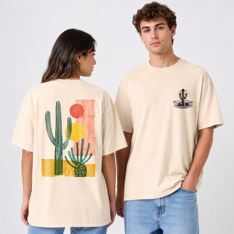 May include: A beige short-sleeve t-shirt featuring a graphic print of a saguaro cactus and a barrel cactus with yellow and red circular shapes on the back, and a smaller matching cactus illustration on the front left chest area.