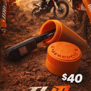 May include: An orange TLM Race Products container with a black tool inside, and a matching lid. The image features a motocross bike in action, with the text "TLM Race Products" at the bottom.