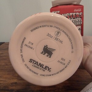 Pu&ograve; includere: Un bicchiere Stanley rosa chiaro con la scritta "Designed in Seattle WA" e "30oz / 887ml". Il fondo del bicchiere presenta il logo Stanley e la scritta "A brand of PMI".