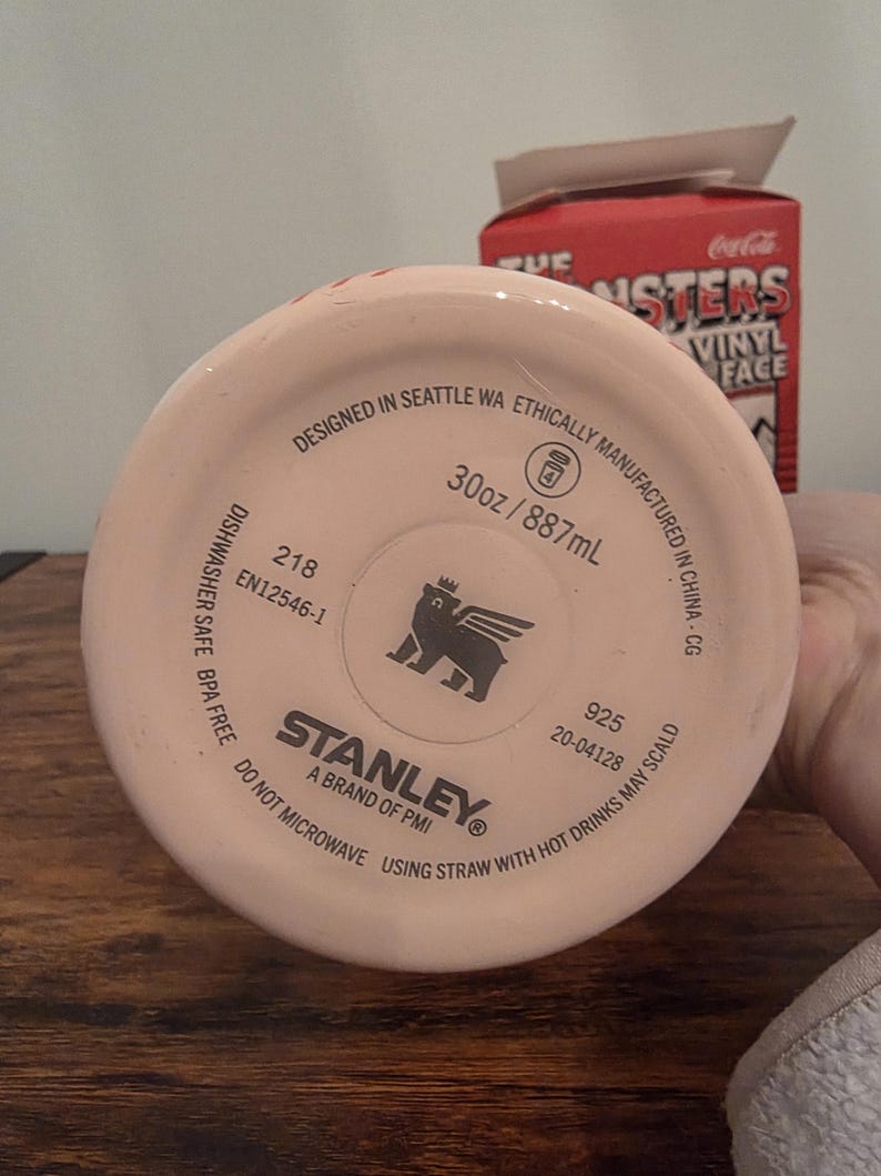 Pu&ograve; includere: Un bicchiere Stanley rosa chiaro con la scritta "Designed in Seattle WA" e "30oz / 887ml". Il fondo del bicchiere presenta il logo Stanley e la scritta "A brand of PMI".