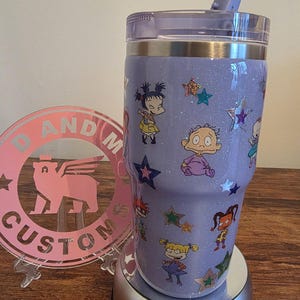 Puede incluir: Una taza de cer&aacute;mica blanca con un asa negra y el texto "But First, Coffee" en negrita negra. La taza se encuentra sobre un fondo neutro, resaltando su dise&ntilde;o simple.