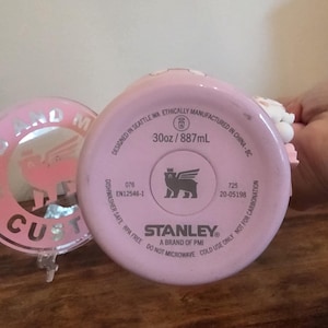 May include: A light pink Stanley brand tumbler base with a 30oz capacity. The bottom features text including 'Designed in Seattle WA', 'Ethically manufactured in China', 'Dishwasher safe', 'BPA free', 'Do not microwave', and 'Cold use only'.