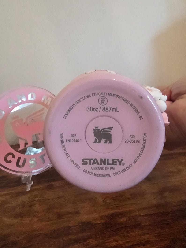 May include: A light pink Stanley brand tumbler base with a 30oz capacity. The bottom features text including 'Designed in Seattle WA', 'Ethically manufactured in China', 'Dishwasher safe', 'BPA free', 'Do not microwave', and 'Cold use only'.