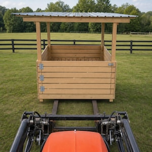 Puede incluir: Un comedero de madera con listones horizontales y un techo de metal corrugado, colocado sobre las horquillas de un tractor naranja. La estructura cuenta con bisagras de metal plateado en los paneles laterales y un diseño abierto.