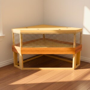 May include: A corner-shaped wooden enclosure featuring a light-toned wood frame, a solid top surface, and a wire mesh paneling that wraps around the front. The structure is supported by a sturdy base with open legs, designed to fit into a room corner.