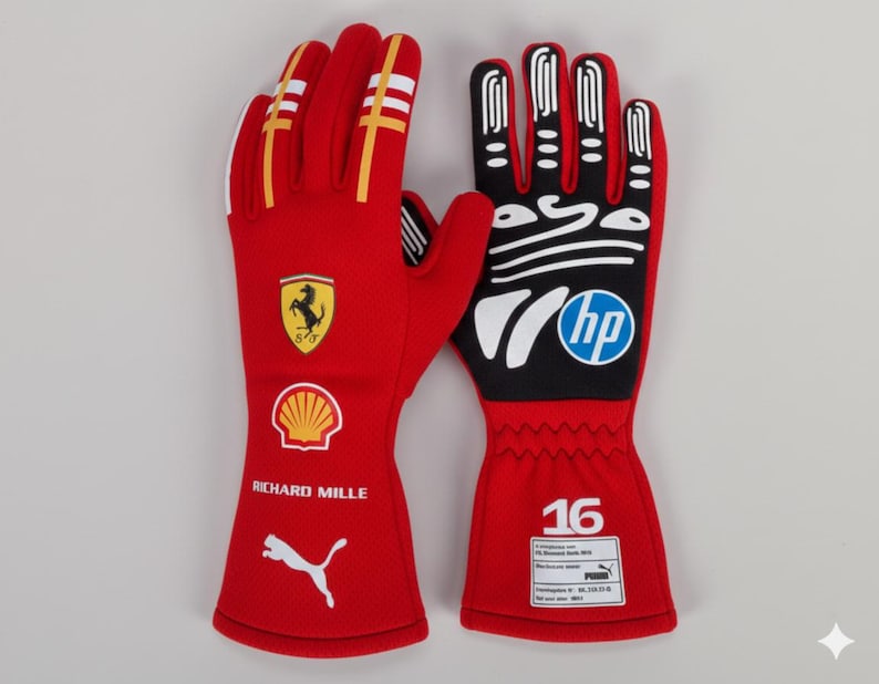 Puede incluir: Par de guantes de carreras rojos con detalles amarillos y blancos. Presentan el logotipo de Ferrari, el logotipo de Shell y el logotipo de Puma. Los guantes tambi&eacute;n tienen el texto "RICHARD MILLE" y el logotipo "hp".
