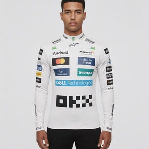 May include: White long-sleeve racing shirt with multiple sponsor logos, including "Android", "McLaren", and "Dell Technologies". The shirt has a high collar and black accents, worn with black pants. The shirt features the text "OKX".
