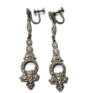 Rari orecchini pendenti Art Déco con strass e metallo.