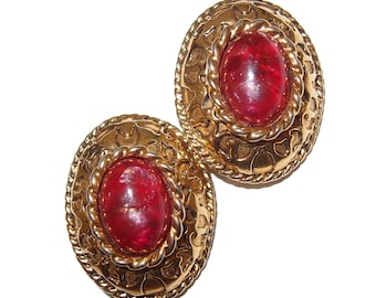 May include: A pair of gold-tone earrings with red glass cabochon stones set in ornate frames.
