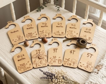 Separadores de madera para ropa de bebé con grabados de animales del bosque.