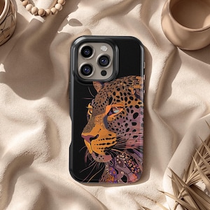 May include: Black phone case featuring a detailed illustration of a leopard's profile. The design incorporates shades of brown, orange, and purple, with a black background. The case is designed to fit a smartphone.