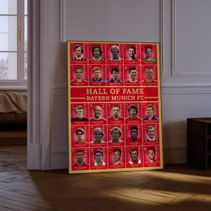 May include: A framed poster featuring the Hall of Fame of Bayern Munich FC. The poster has a gold frame and a red background with player portraits. The text "HALL OF FAME" and "BAYERN MUNICH FC" are displayed prominently.