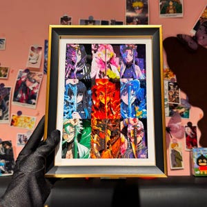 Könnte beinhalten: Gerahmtes Kunstwerk mit neun farbenfrohen Anime-Charakterporträts. Das Kunstwerk befindet sich in einem schwarzen und goldenen Rahmen. Die Charaktere haben eine Vielzahl von Haarfarben und halten Schwerter. Der Hintergrund ist eine rosa Wand mit anderen Kunstwerken.