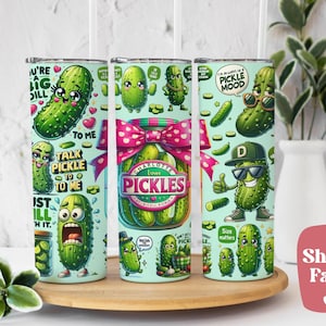May include: Three 20 oz. insulated tumblers with pickle-themed designs. Each tumbler features cartoon pickle characters and phrases like "I'm always in a pickle mood." One tumbler has a jar of pickles with a pink bow. The tumblers are on a wooden tray.