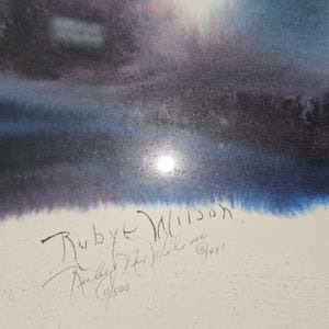 May include: Watercolor painting depicting a night scene with a bright moon. The artwork features shades of blue, purple, and white, with the artist's signature and the text "Ruby Wilson" and "11/500" visible.
