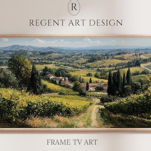 May include: A horizontal landscape painting in a light wood frame depicting a rolling countryside with vineyards, cypress trees, and a small village under a blue sky. The text REGENT ART DESIGN and FRAME TV ART is printed above and below the artwork.