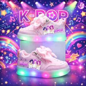 Puede incluir: Zapatillas rosas con luces con tem&aacute;tica K-POP. Los zapatos tienen un lazo, cremallera y una suela luminosa de colores. El lateral del zapato presenta un gr&aacute;fico de tres chicas de dibujos animados. La palabra "K-POP" est&aacute; impresa en el lateral.