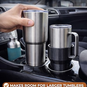 May include: A car cup holder expander with a stainless steel tumbler and a black cup holder. The text "CAR CUP HOLDER EXPANDER" is at the top of the image. The text "MAKES ROOM FOR LARGER TUMBLERS" is at the bottom.