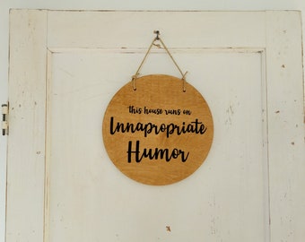 This House Runs On Inappropriate Humor - 12" Round Door Hanger in Walnut