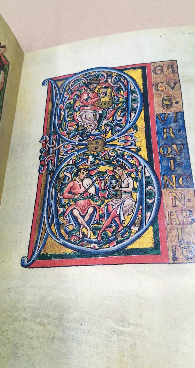 Może przedstawiać: Strona z iluminowanego manuskryptu z dużą, ozdobną literą początkową &bdquo;B&rdquo;. Litera zawiera ilustracje postaci grających na instrumentach, osadzone w skomplikowanych wzorach kwiatowych i liściastych, w żywych kolorach.
